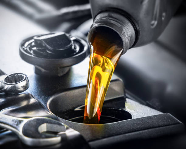 after changing the oil, pour in the fresh engine oil - motor oil bottle imagens e fotografias de stock