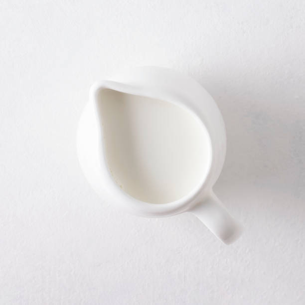 istock Milk jug on a white background, top view, closeup. 1326616294