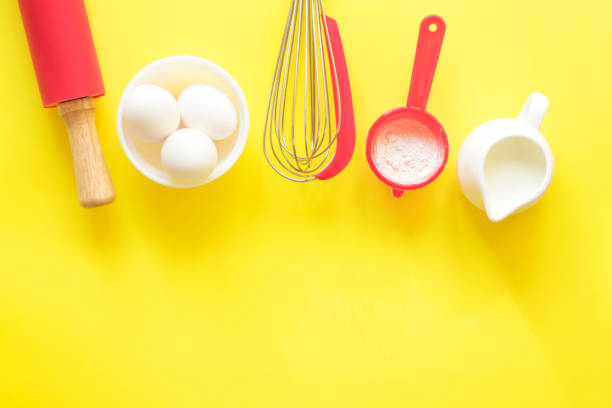 istock Ingredients and devices for baking. Flour, eggs, milk, rolling pin, whisk on a yellow background, copy space, top view, flat lay. 1326617713