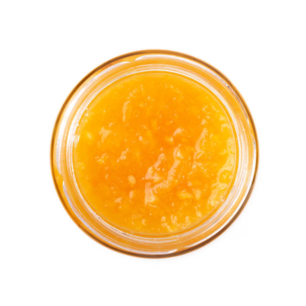 istock Orange jam in a jar on a white isolated background, top view. 1326617862