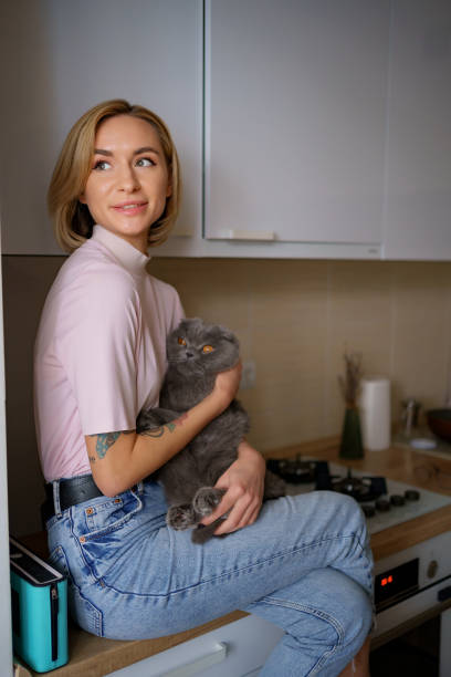 istock Woman siting on kitchen hugging a cat 1326622238