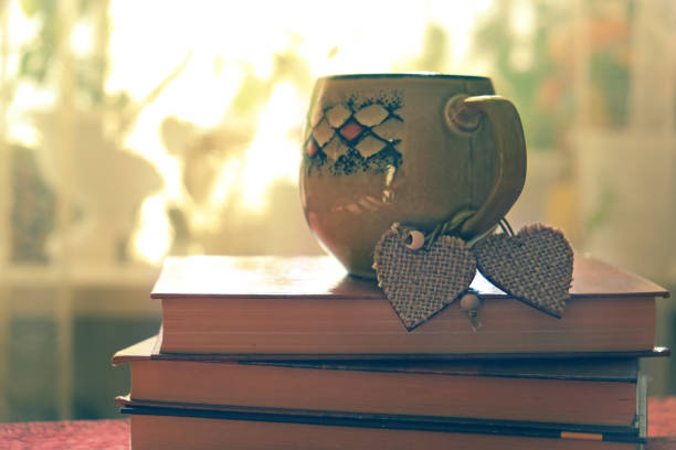 Valentines day concept. Cup and  two  hearts on books, retro effect noise and grain