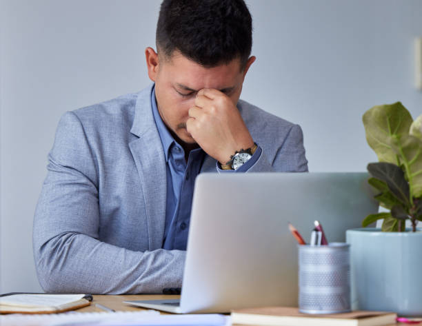istock Shot of a young businessman experiencing a headache while at work 1326625051