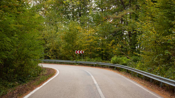 istock Old asphalt road in autumn forest 1326627177