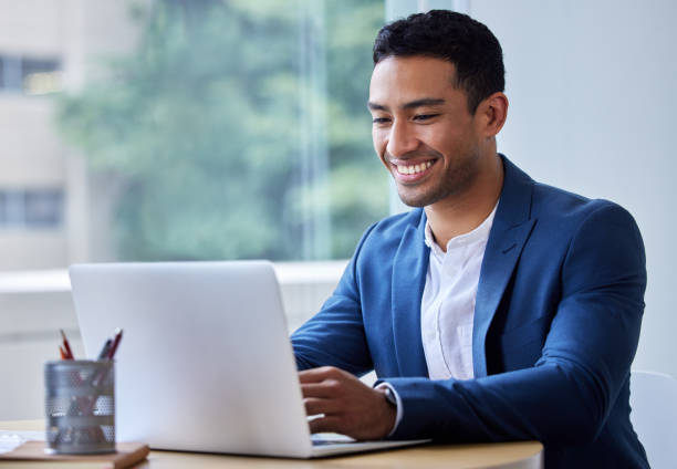 shot of a young businessman working on his laptop - men laptop businessman using laptop imagens e fotografias de stock