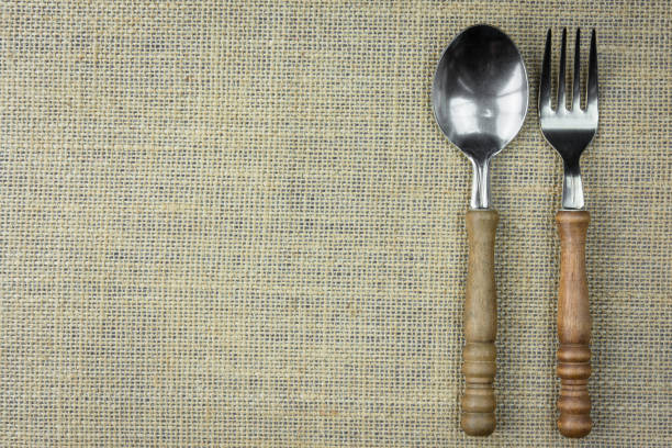 istock Spoons and forks on sackcloth. Old vintage kitchen ware on table. Top view with copy space. 1326627957