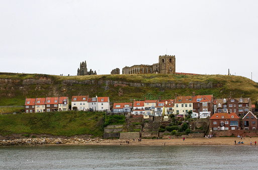 Colour photograph of the Church of St Mary graveyard & Whitby Abbey in England