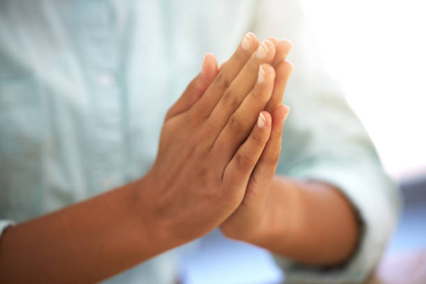 foto recortada de una persona irreconocible sentada con las manos juntas - praying fotografías e imágenes de stock