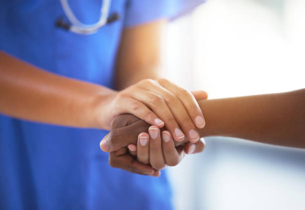 shot of an unrecognizable doctor holding hands with her patient during a consultation - patient doctor african descent hospital imagens e fotografias de stock