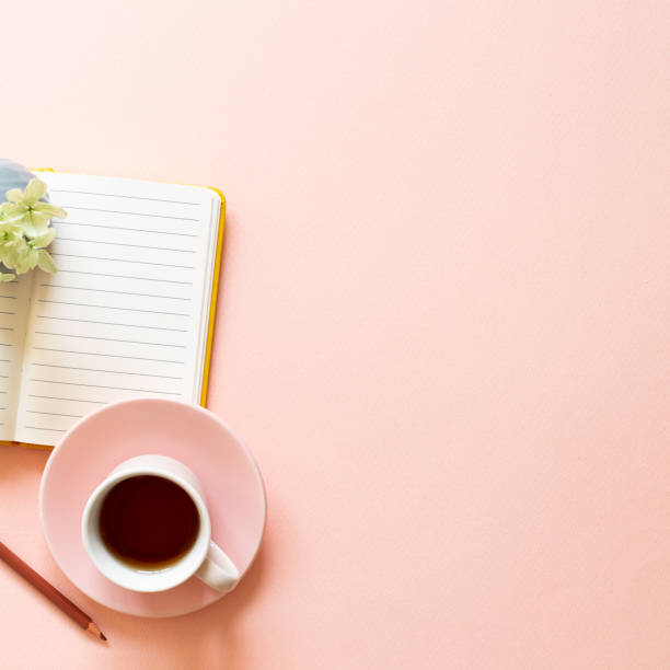 istock Open notebook, cup of tea, dry flowers on pink background. Daily life, workspace, study concept 1326639698