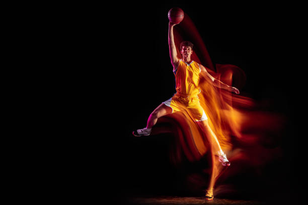 istock Young Caucasian basketball player training isolated on black background in mixed neon lights. 1326640652