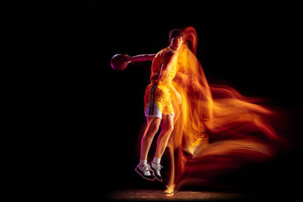 istock Young Caucasian basketball player training isolated on black background in mixed neon lights. 1326640675
