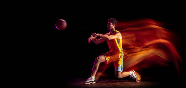 istock Young Caucasian basketball player training isolated on black background in mixed neon lights. 1326640689