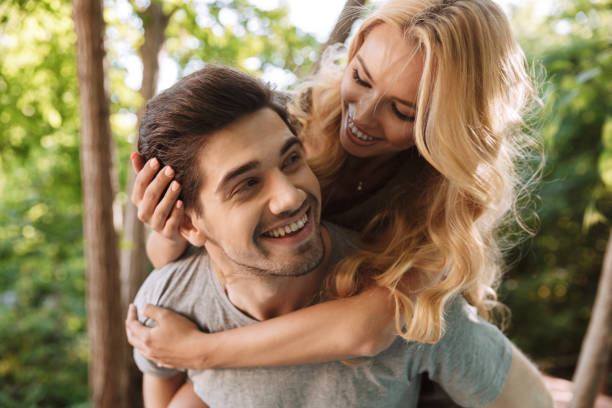 istock Happy young man carrying his beautiful girlfriend on his back 1326640946