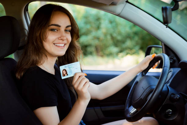 studente in un'auto moderna che mostra la patente di guida - status symbol foto e immagini stock