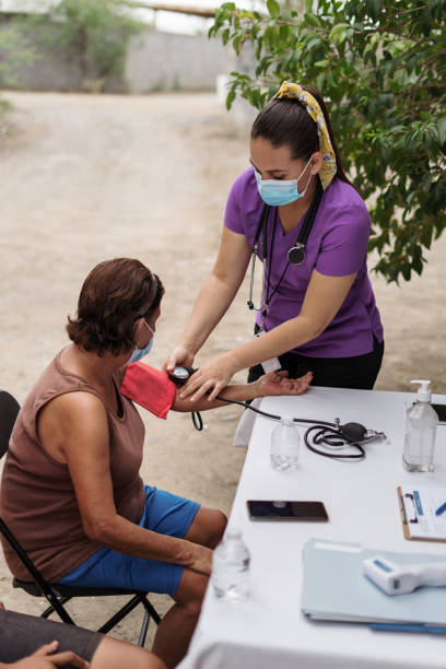 istock Nurse wearing face mask and checking blood pressure outside 1326646814
