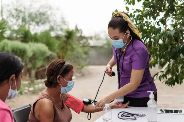 Photo of Nurse on brigade checking senior patient outside