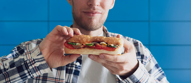 person eating sandwich for lunch, fast food lifestyle