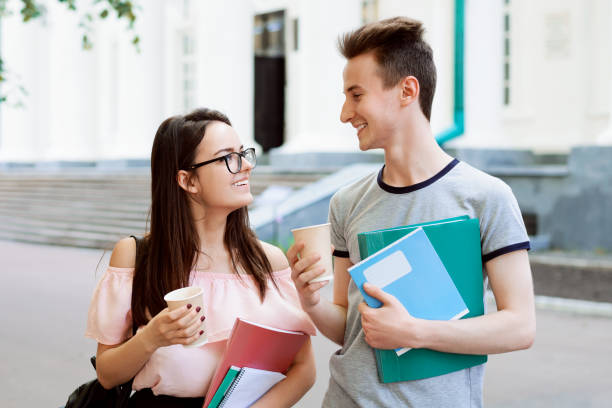istock Young woman and man having fun together after classes, drinking coffee and having good time 1326648558