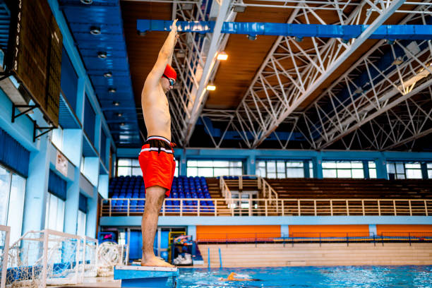 istock Man preparing for a jump in an indoor pool 1326651212