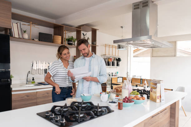 istock Couple at home checking a letter in the mail 1326651838