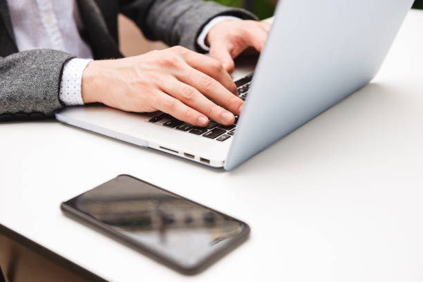 istock Close up of male hands typing on laptop computer 1326652408