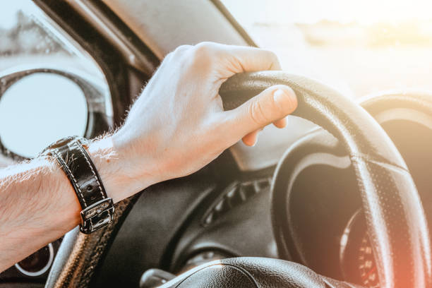 istock Hand holding steering wheel in a Car 1326654562