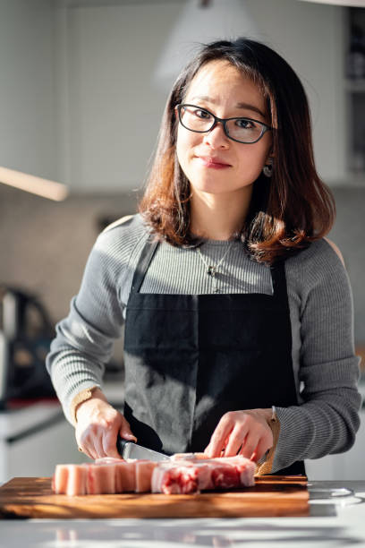 istock Asian woman chopping pork for the dinner 1326655088