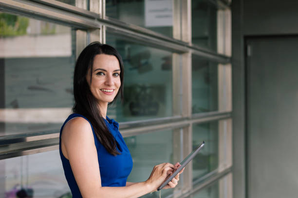 istock Hispanic business woman using her digital tablet in the office and looking at camera. Technology concept. 1326660682