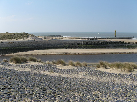 Sandy beach with pavilion.