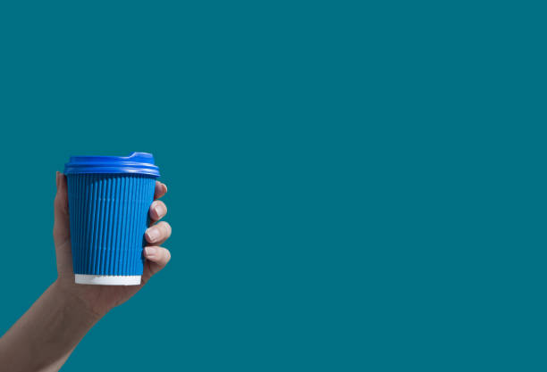 istock Cardboard cup of coffee or tea on a blue background with copy space. Hot drinks to go minimalistic concept 1326665975