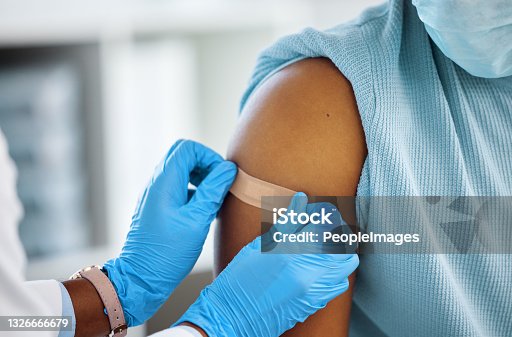 istock Shot of a doctor applying a plaster to her patients arm 1326666679