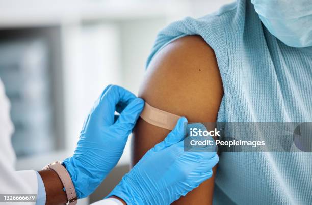 Shot Of A Doctor Applying A Plaster To Her Patients Arm Stock Photo - Download Image Now