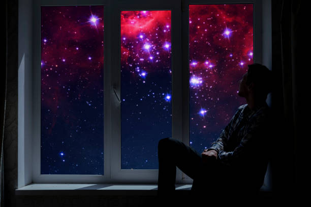 istock person standing next to the window and watching outside, admire the star on night sky, elements of this image furnished by nasa 1326668965