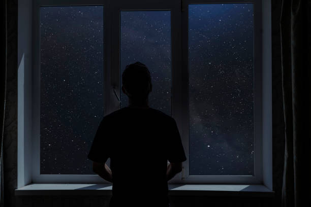 istock person standing next to the window and watching outside, admire the star on night sky, elements of this image furnished by nasa 1326668967