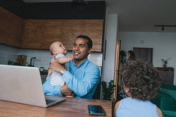istock Father taking care of son while working on laptop  at home 1326670954