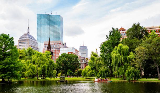 Boston Public Garden Lake - Back Bay - Boston Massachusetts Boston Public Garden. Located in the heart of Boston, adjacent to Boston Common. A swan boat full of tourist on the lake, and Back Bay buildings in the background. boston massachusetts stock pictures, royalty-free photos & images