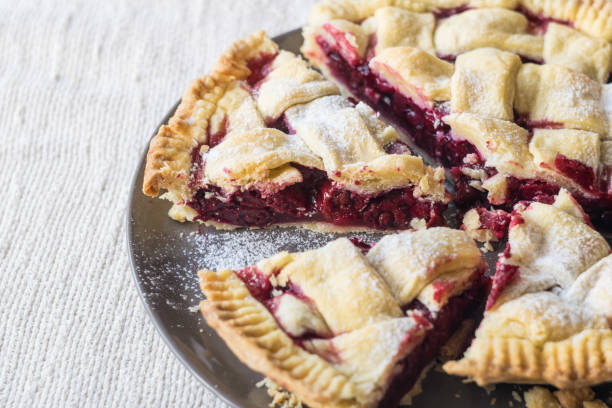 istock Cutted cherry pie cake on grey plate on light linen textile background, selective focus 1326671747
