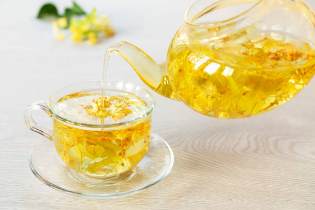 istock Herbal tea from lime blossoms is poured from the kettle into the cup. The concept of alternative medicine. 1326678300