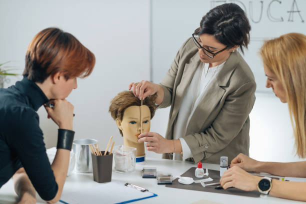 Permanent Eyebrow Training Course Permanent eyebrow training course. Female cosmetologist with adult students in cosmetology education center beauty spa stock pictures, royalty-free photos & images