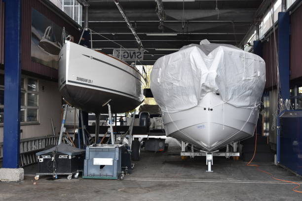 two white yachts stored in undercover  workshops and ready for repair in marina harbor of city of lucerne situated on lake lucerne - yacht nautical vessel luxury moored imagens e fotografias de stock