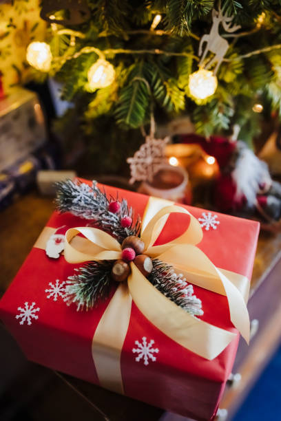istock beautifully wrapped red gift box under the christmas tree, top view 1326688302