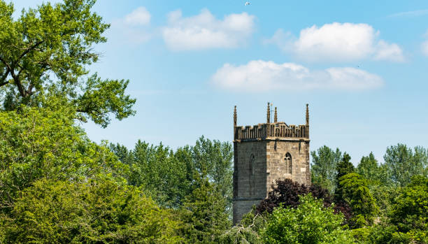 istock Historic church tower and trees against a bright blue sky 1326689732