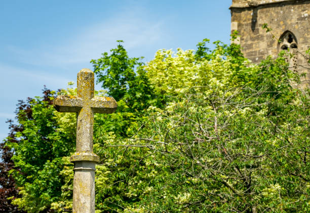 Selective focus on a concrete cross outside a church in rural England