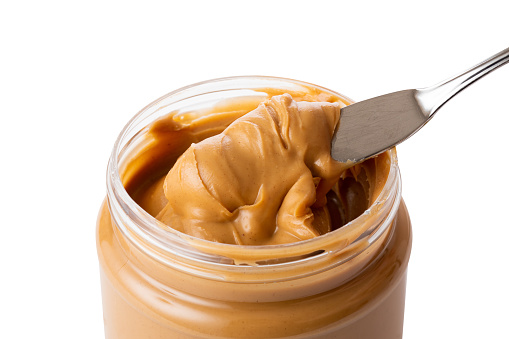 open jar of peanut butter with spoon