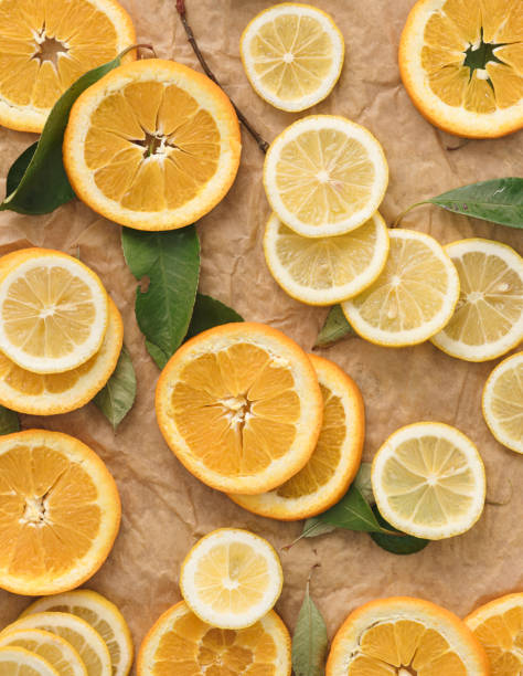 Slices of orange, lime and lemon speeded on brown background.