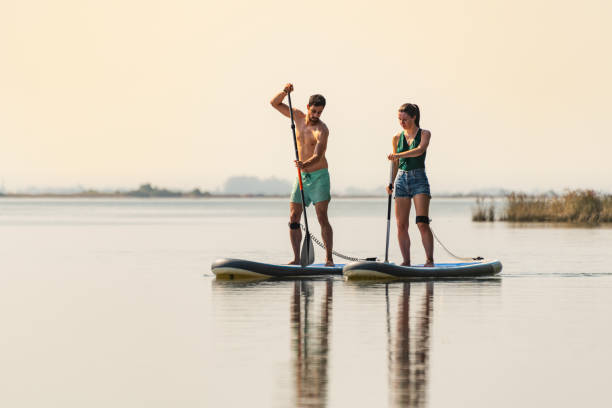 istock Man and woman stand up paddleboarding 1326702966