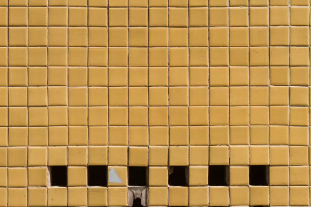 istock WA wall surface with small yellow tiles and holes 1326705440