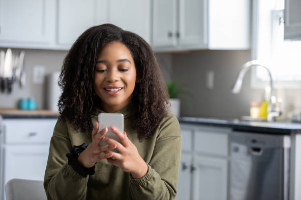 istock Teenager smiling during virtual appointment on her cell phone 1326707801