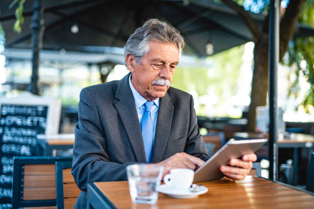 istock Senior Businessman Using Digital Tablet During Coffee Break 1326709158
